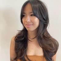 a young asian woman with long hair posing for a photo